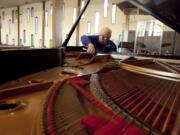 Ken Serviss, a longtime Vancouver resident and music educator, tunes the piano at Columbia Presbyterian Church.