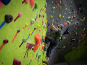 James Carr, 25, of Vancouver climbs a rock wall Wednesday at a new fitness center ahead of its scheduled Friday opening.