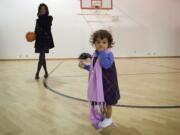 Sojourner Yokum, 15 1/2  months, pauses while playing basketball with her mother Genevieve Fisher, 29, in the gymnasium at St. Andrew Lutheran Church. They spent Sunday night as guests of the Winter Hospitality Overflow program.