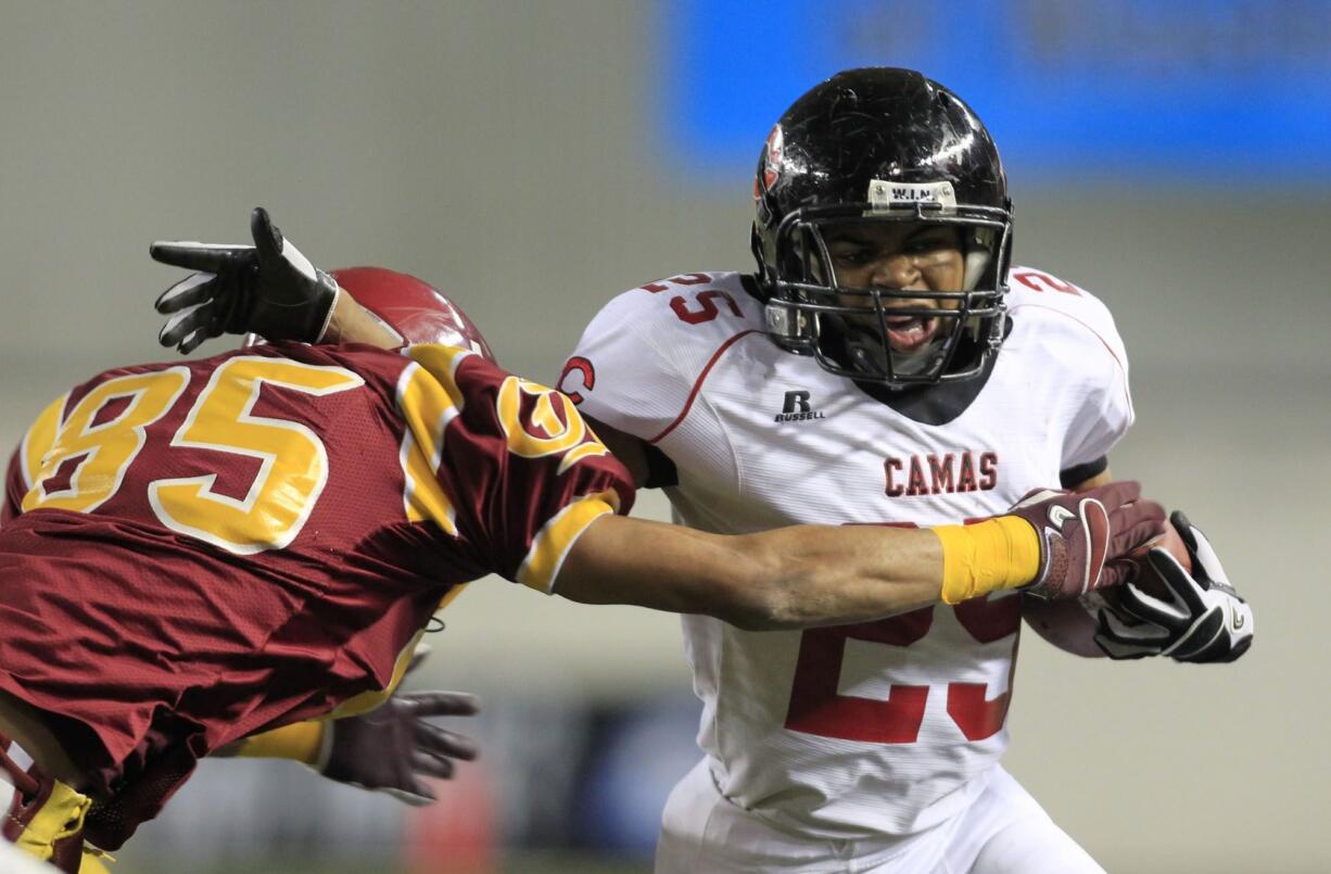 Camas' Zack Marshall (25), fighting off O'Dea's Tyler Longmire, rushed for 51 yards on six carries in the first quarter before leaving with a dislocated thumb.