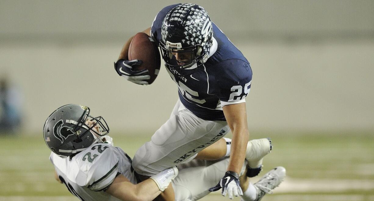 Skyline's Connor Gilchrist (22) makes a tackle on Skyview's Mo Morrison (25) during the first half of Saturday's 4A championship game at the Tacoma Dome.