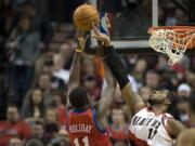 Trail Blazers forward LaMarcus Aldridge blocks the shot of the 76ers' Jrue Holiday during the first half of the season opener at the Rose Garden on Monday December 26, 2011.