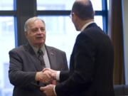 New City Councilor Bill Turlay shakes hands with County Auditor Greg Kimsey after he was sworn in at at City Hall on Thursday morning.