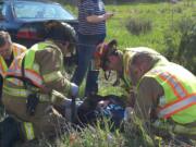 Paramedics work to stabilize a patient injured in a Thursday afternoon auto accident near Hockinson High School.