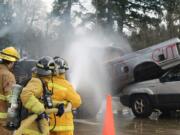 Fern Prairie: Citizen Academy participants Martha Martin and Sheila Plato work with East County Fire &amp; Rescue intern firefighter/EMT Reece Bonenfant to extinguish a fire in the cab of a truck during a Citizens Academy.