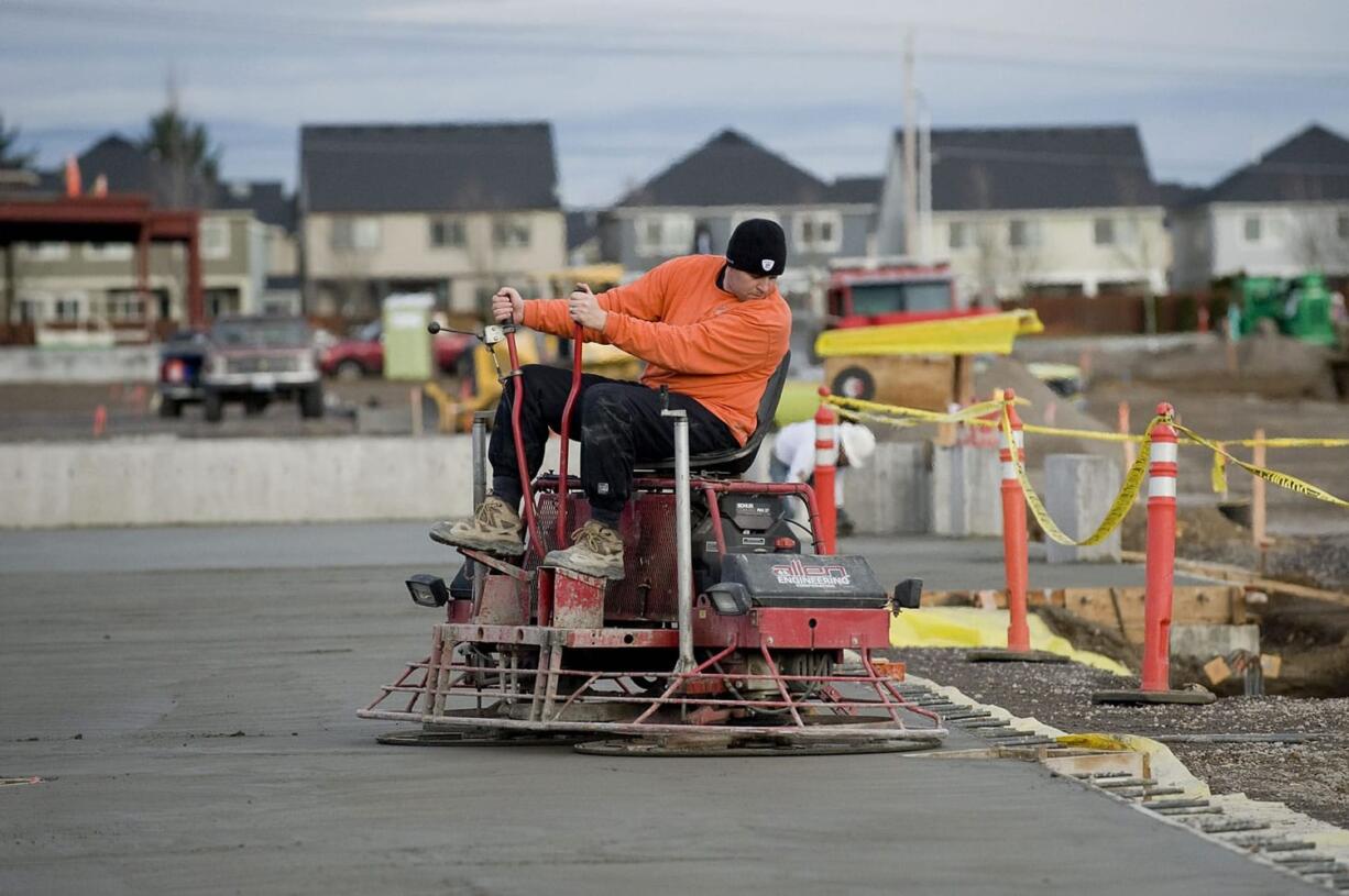 Brenden Hogberg from A Lite Construction uses a riding power trowel on fresh concrete at the construction site for 192 Avenue Station, a new retail center being built at Southeast 192nd Avenue and 20th Street in east Vancouver.