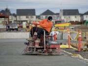 Brenden Hogberg from A Lite Construction uses a riding power trowel on fresh concrete at the construction site for 192 Avenue Station, a new retail center being built at Southeast 192nd Avenue and 20th Street in east Vancouver.