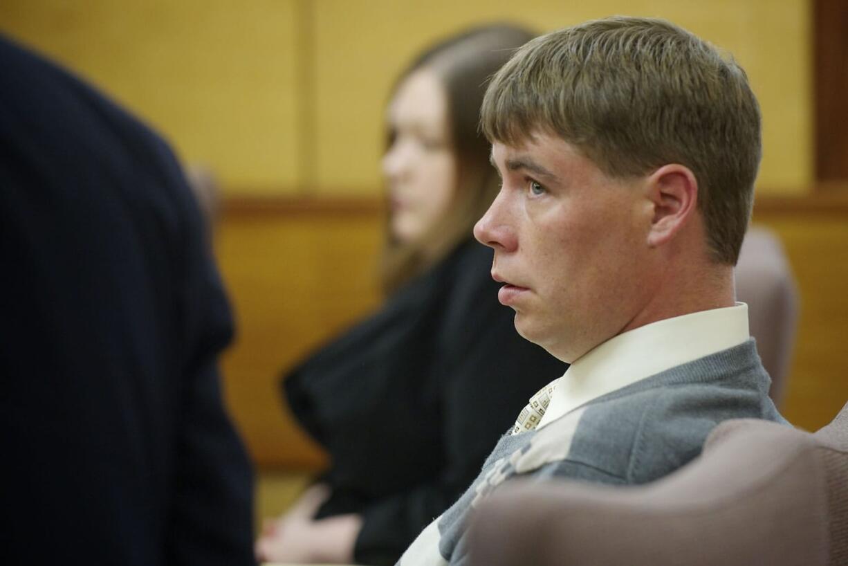 John Eckhart listens to his attorney, Jon McMullen, Monday  in Vancouver during opening statements in the trial in which he and his wife, Alayna Higdon, are accused of locking  their two young autistic boys in a caged room.