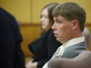 John Eckhart listens to his attorney, Jon McMullen, Monday  in Vancouver during opening statements in the trial in which he and his wife, Alayna Higdon, are accused of locking  their two young autistic boys in a caged room.