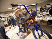 Dean Large, sales manager at Waste Connections, on Thursday builds a bike to be donated to needy children.