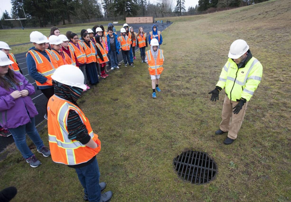 Sixth-grade students listen to Lance Lehto, president of Columbia West Engineering, talk about water drainage and construction of two new schools that will be built behind Jemtegaard Middle School.