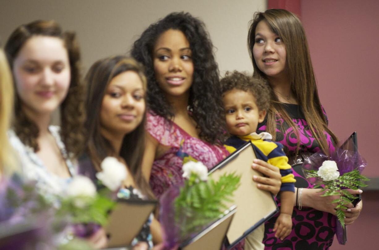 Desiree Barrera-Poulsen, right, and about a dozen other pregnant and parenting teens are recognized for completing the GRADS program during a ceremony at the Bates Center in Vancouver Wednesday.