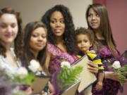 Desiree Barrera-Poulsen, right, and about a dozen other pregnant and parenting teens are recognized for completing the GRADS program during a ceremony at the Bates Center in Vancouver Wednesday.