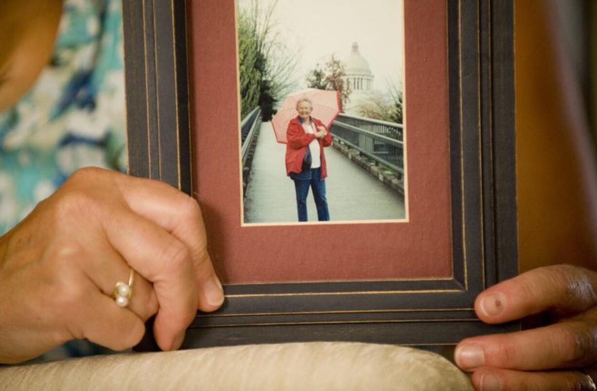 Debbie Johnson holds a photo of her mother Mildred &quot;Mickey&quot; Newman. Johnson discovered in March that the nursing assistant accused of assaulting her mother two years earlier while she lived in an adult family home was still licensed to work in the state.