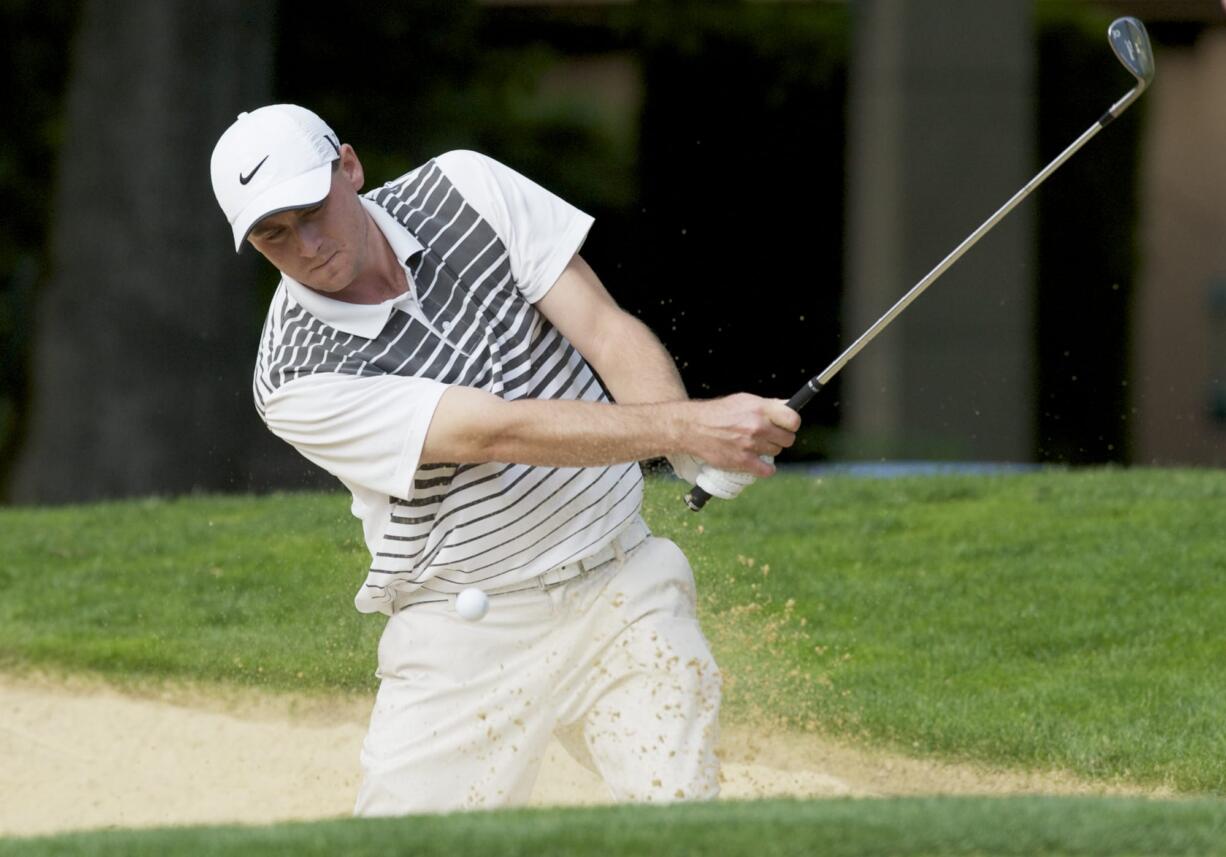 Landon Banks chips out of the bunker to the 12th green at Royal Oaks Country Club.