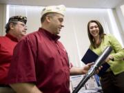 Steven Lane/The Columbian Ryan Nabors, Washington commander of Disabled American Veterans, presents U.S. Rep. Jaime Herrera Beutler with a baseball bat during a reception Monday.