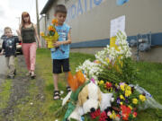 Titus Martin, 7, right, with his mom Mandie Martin and brother Parker Martin, 9, deliver flowers to a memorial for Benjamin Fulwiler at the intersection of Main and 27th streets on Sunday.