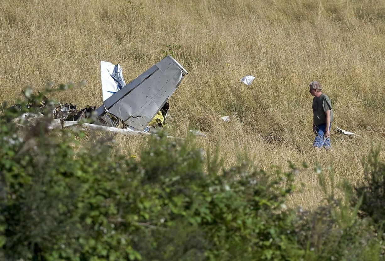 An investigator examines the wreckage of a light plane near Fern Prairie, north of Camas, Wednesday.