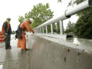 Construction workers Brad Wolf and Jeff Cummings of Zemek install pedestrian rails as work continues on the St. Johns Boulevard/state Highway 500 interchange project in Vancouver. Motorists on St.