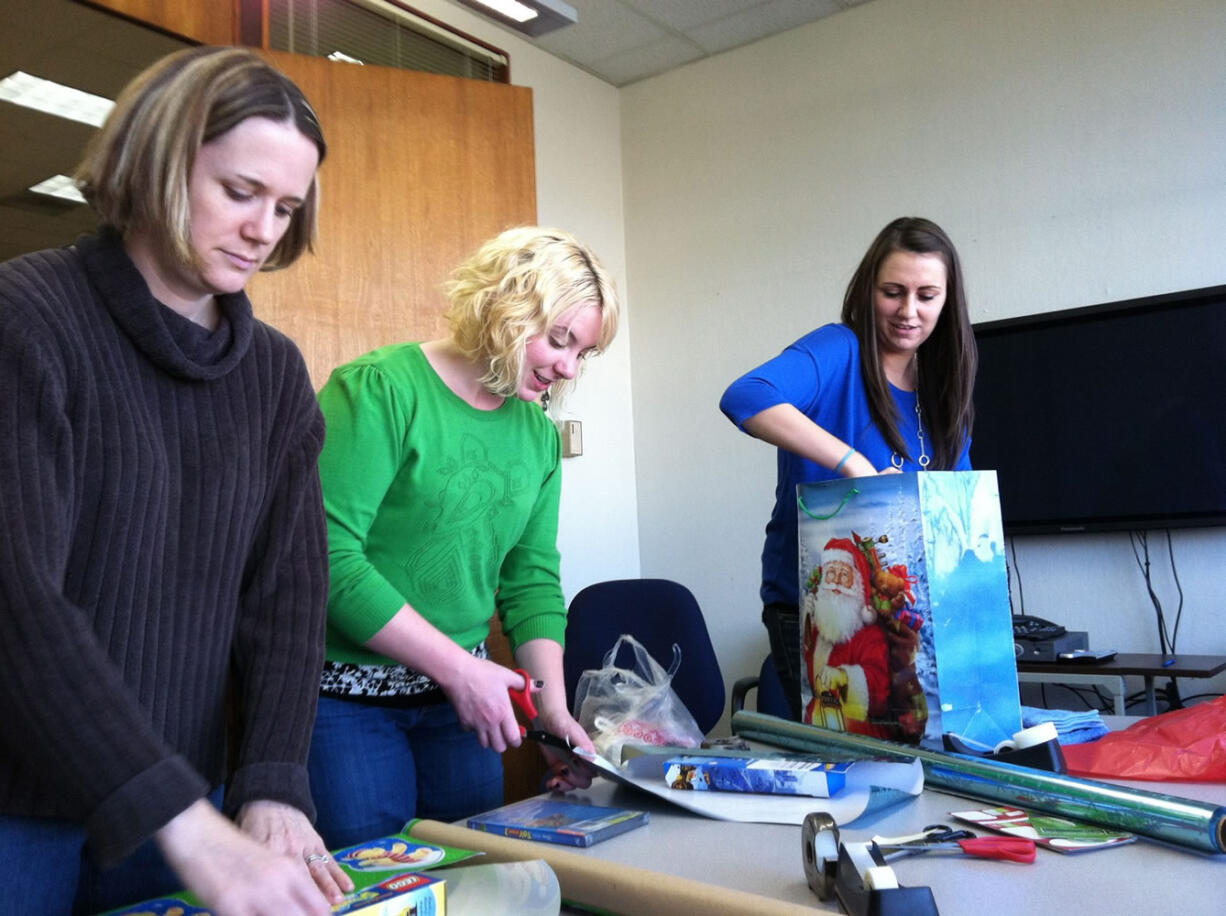 Reporters Stephanie Rice, from left, Andrea Damewood and Marissa Harshman help make Christmas merry for one family.