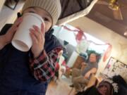 Edgewood Park: Henry Beagle, left, sips a drink under the watchful eye of his father, Andrew, second from right, and Santa Claus during an opportunity to meet Santa at Paper Tiger Coffee Roasters in Vancouver.