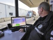 Commercial vehicle enforcement officer Robert Schultheis with the Washington State Patrol uses a computer with new software to monitor big rigs on Interstate 5 in Ridgefield.