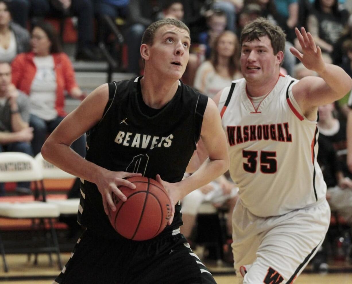 Woodland center Bryce Mulder (0) shoots as Washougal center Josh Bischoff (35) defends.