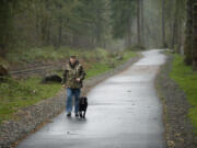 Ray Holbrook walks his dog, Pearl, on the new Chelatchie Prairie Railroad Trail near Battle Ground Lake State Park last week.