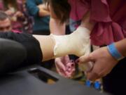 Students compete Saturday in a timed ankle-taping event at the Washington Career and Technical Sports Medicine Association's State Sports Medicine Competition and Symposium at the Hilton Vancouver Washington.