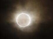 The moon slides across the sun, showing a blazing halo of light, during an annular eclipse viewed from a waterfront park in Yokohama, near Tokyo, on Monday. Millions of Asians watched as a rare &quot;ring of fire&quot; eclipse crossed their skies early Monday.