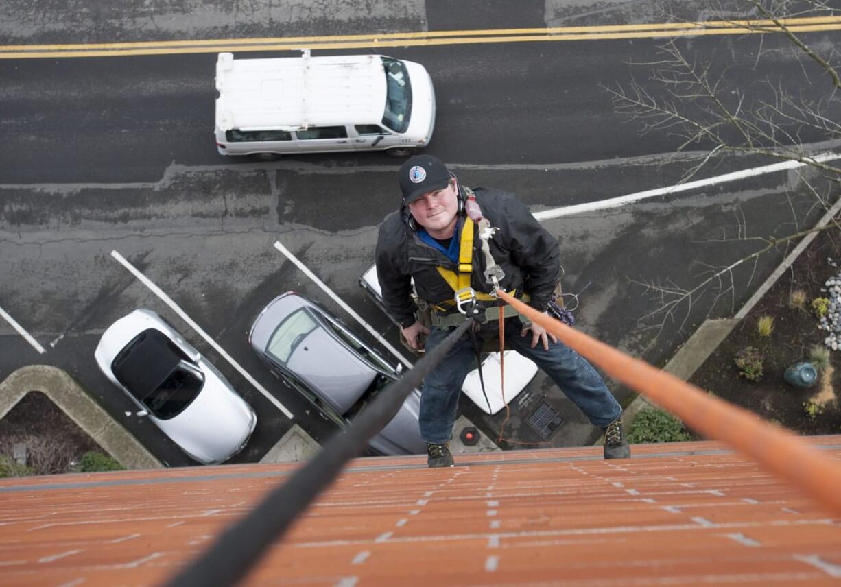 Greg Guetlin is seen on the job in downtown Vancouver. Guetlin is employed washing windows as well as the exteriors of buildings, including many multistory structures.