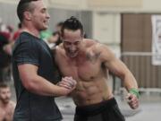 Cameron Pernich, left, of Gresham, Ore., and Sun Chang react to being first to cross the finish line during one of the events Sunday at the CrossFit Fort Vancouver Championship at the Clark County Event Center at the Fairgrounds. Pernich described Chang, from Boise, Idaho, as his workout mentor.