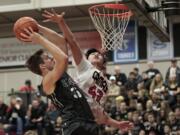 Union forward Denis Kirichenko, left, shoots against Camas&#039; Bryan Nguyen, right. Union held off the Papermakers 58-54 to take a three-game lead in the 4A Greater St. Helens League.