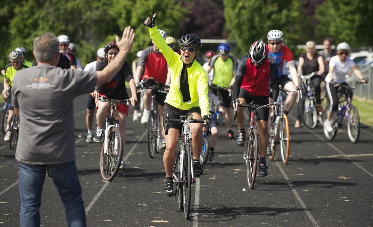 Photos by STEVEN LANE/The Columbian 
 Supporters follow Lori Salierno as she starts her 3,000 mile bicycle journey to Georgia on Sunday at Mountain View High School in Vancouver. She is raising money for her organization, Celebrate Life International, which helps at-risk students.