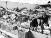 Searchers race in and out of the demolished Waremart store, where five people were killed in Vancouver on  April 5, 1972.