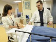 Kati Kleiser, left, a lab instructor at Clark College's nursing program, and Kris Fowell, a nursing department technician, examine &quot;Fred,&quot; a Sim mannequin Kleiser used when she herself was a student in the program 10 years ago.