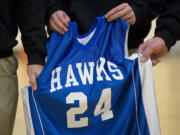 Members of La Center Middle School's basketball coaching staff hold the jersey of Cody Sherrell during a ceremony honoring the boy Thursday inside the school's gym. Cody died Jan.