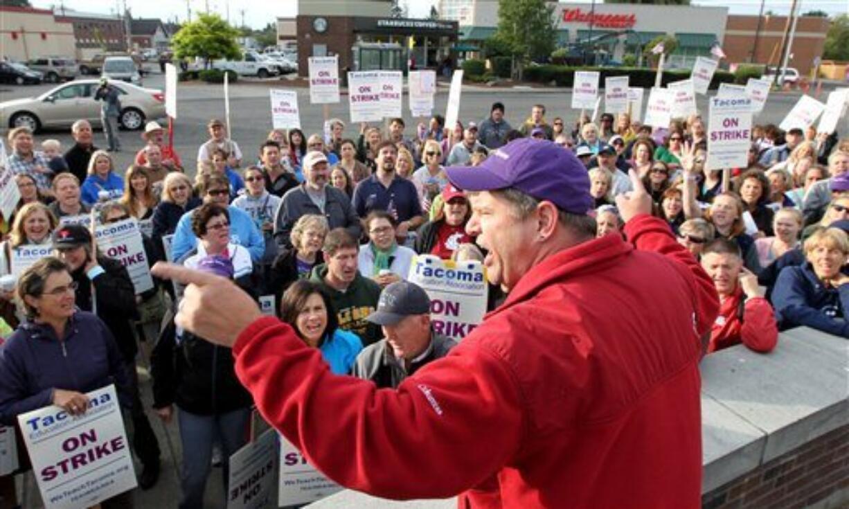 Dave Baughman, cheers on striking teachers gathered to picket in front of Jason Lee Middle School, in Tacoma, Wash. on Thursday, Sept. 15, 2011. Teachers in Washington state's third-largest school district have voted overwhelmingly to remain on strike, in defiance of a judge's order that they return to work. The teachers walked out Tuesday over issues including pay and how job transfers are handled. A state judge issued an order Wednesday that they go back to class, but the teachers refused.