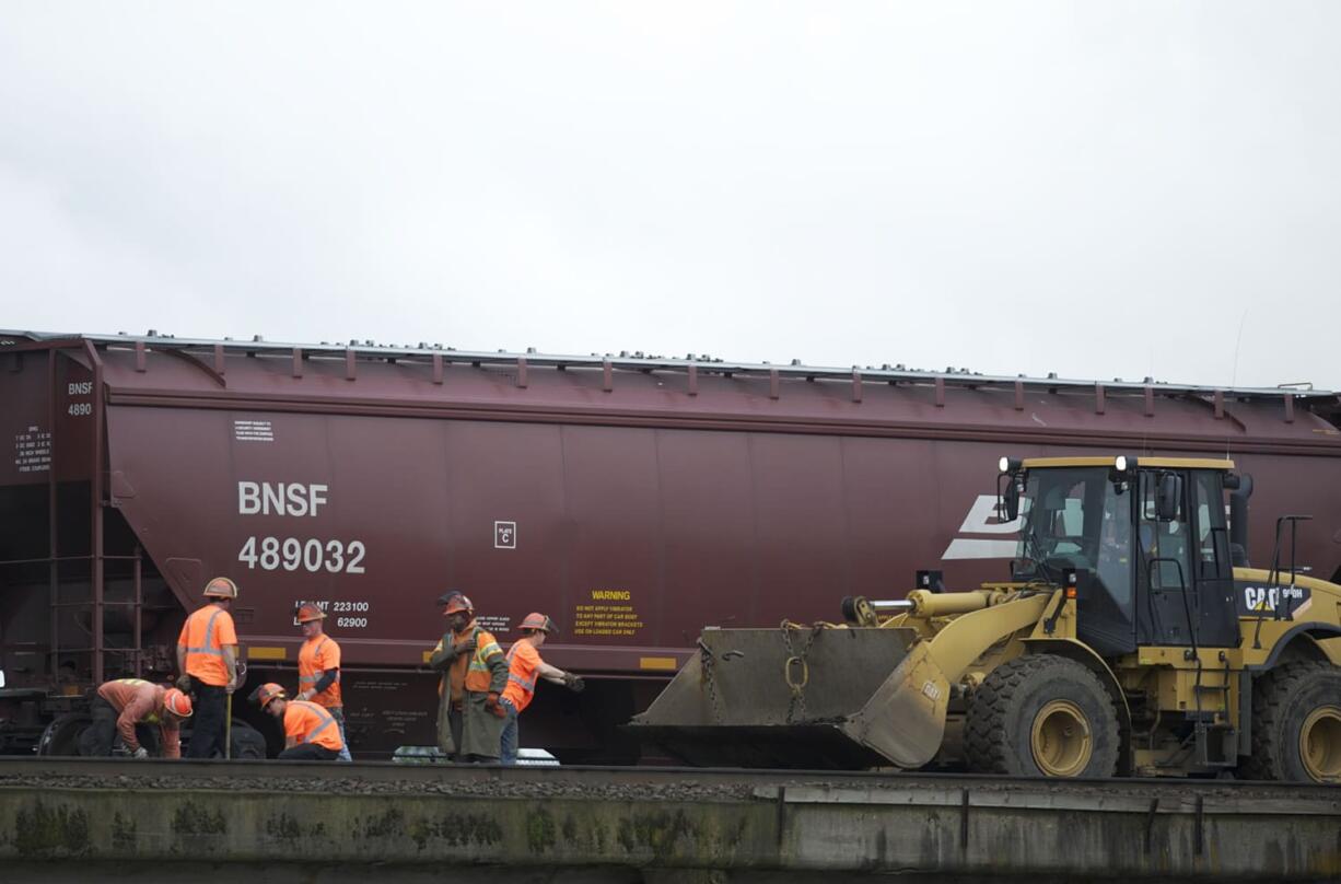 BNSF Railway contractors work on the track at the south end of Esther Street on Friday.