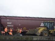 BNSF Railway contractors work on the track at the south end of Esther Street on Friday.