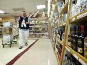 Eric Simonson stocks liquor shelves at a State owned liquor store, #10, one of the oldest stores in the system, Monday in Vancouver