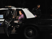 Vancouver police and Washington State Patrol officers place protester Pamela McCarty in a police vehicle.