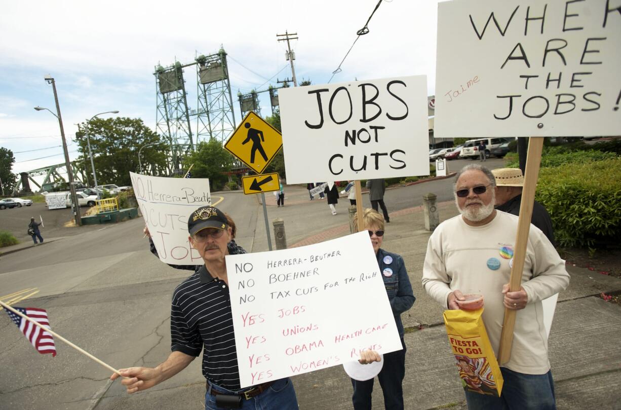 Demonstrators line Columbia Street on Friday as U.S. Rep. Jaime Herrera Beutler, R-Camas, kicks off her campaign for re-election at a private event at the Red Lion Hotel Vancouver at the Quay.