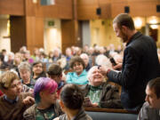 Phil Arnold's grandson, Adam Arnold, reads from a list of quotes at his grandfather's memorial service at the First United Methodist Church on Sunday.