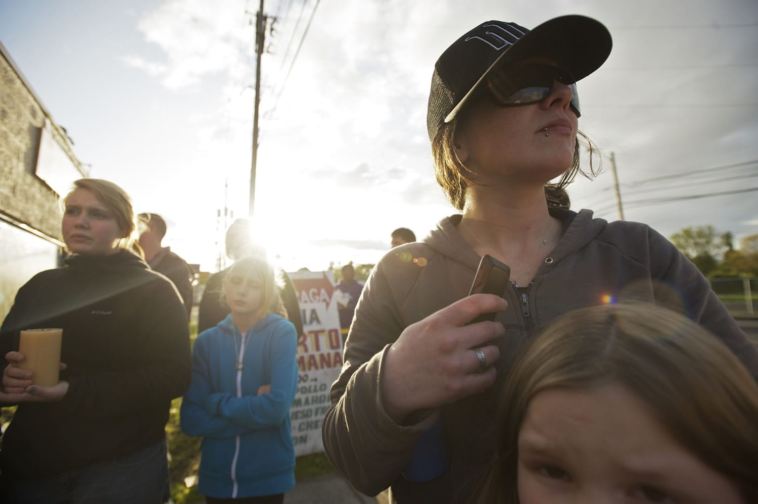 Steven Lane/The Columbian
Misty Valenzuela, 31, in the baseball cap, and her niece Madison Valenzuela, 7, right, pay respects to Maria Delos-Carrasco Angulo on Friday night outside Becerra's Plaza in Vancouver. The aunt witnessed the Thursday night hit-and-run that killed.