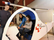 Victoria Quintero, seated, with her parents Tanya Quintero and Jaider Quintero, left, examines a hands-on helicopter display at Pearson Air Museum.