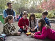 Eisenhower Elementary School fifth-grader Lily Hensley, from left, joins teacher Erick Hoffarth as well as fellow fifth-graders Joey Douglas, Lindsey Slaton, Hallie Hoffarth and Matthew Davidson as they build a solar-powered car in November at the Water Resources Education Center.