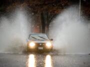 A car plows into standing water on Northeast 136th Avenue near Northeast Fourth Street in Vancouver on Tuesday.