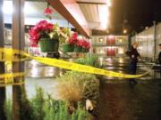 In this Feb. 12, 2012, photo, Astoria Police officers stand watch outside of the Lamplighter Motel on Marine Drive in Astoria following a shooting. A man was wounded in a shootout with police at the motel and the suspect fled but was stopped about 25 miles away after a chase along the coast on U.S.