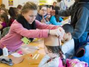 Woodland: Woodland High School students show children from the Woodland Preschool Cooperative how to make reindeer hats as part of the high school&#039;s Early Childhood Development program.